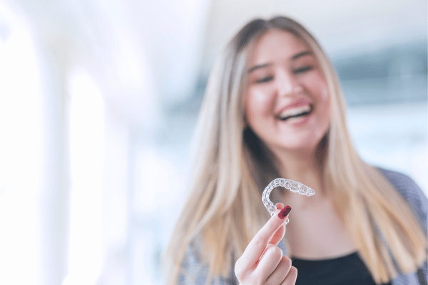 woman holding clear aligners