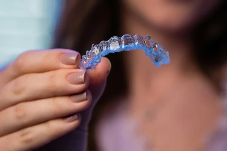 Woman holding clear aligners